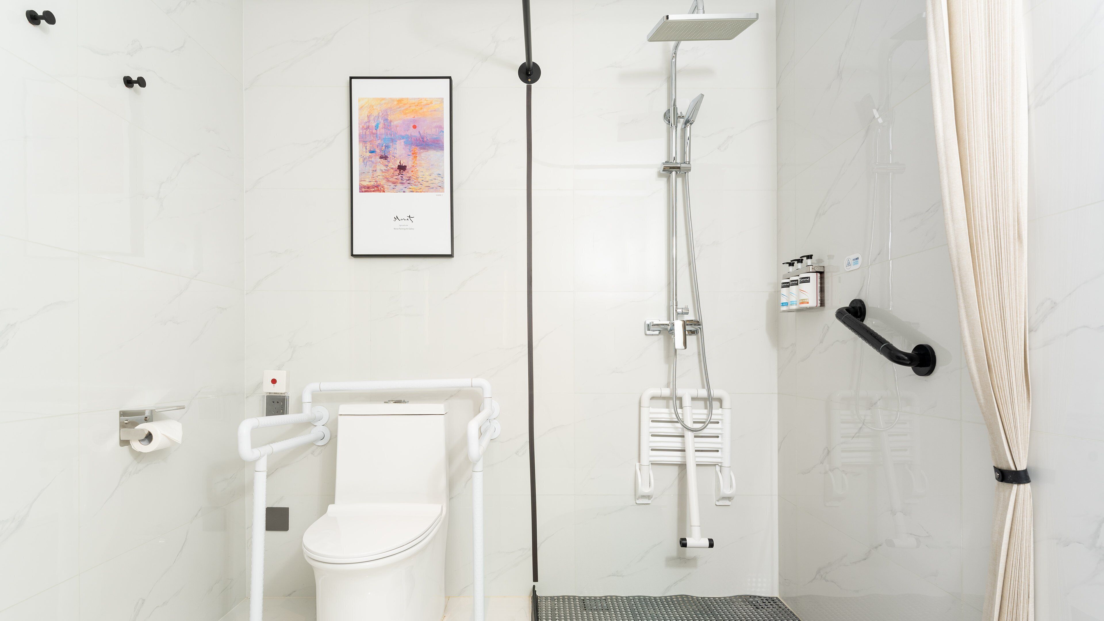 A modern bathroom with a toilet, shower, and a framed artwork on the wall.