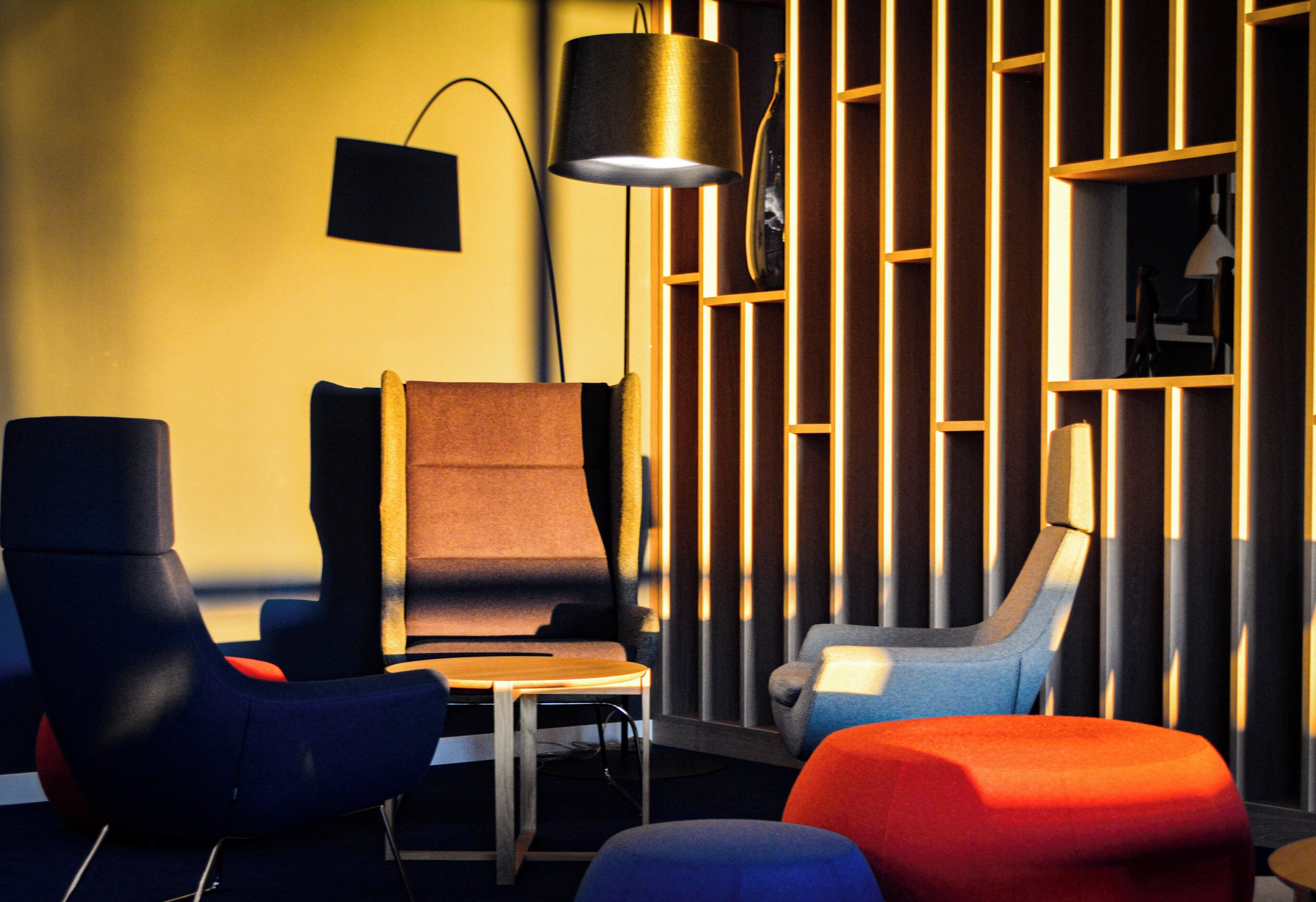 A modern lounge area with a sofa, armchairs, and a small table.
