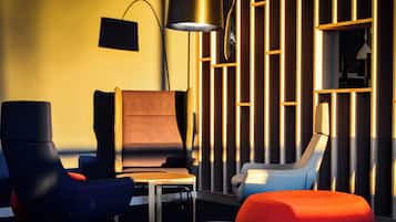 A modern lounge area with a sofa, armchairs, and a small table.