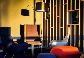 A modern lounge area with a sofa, armchairs, and a small table. - Holiday Inn Express Munich Olching by IHG (Olching)