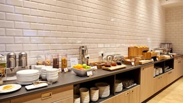 A buffet setup with various food items and serving utensils.