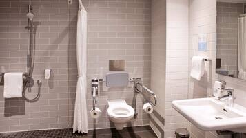 Un baño moderno con ducha, inodoro y lavamanos.