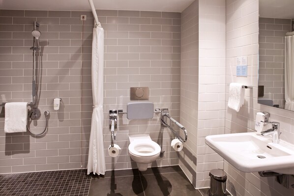 A modern bathroom with a shower, toilet, and sink.