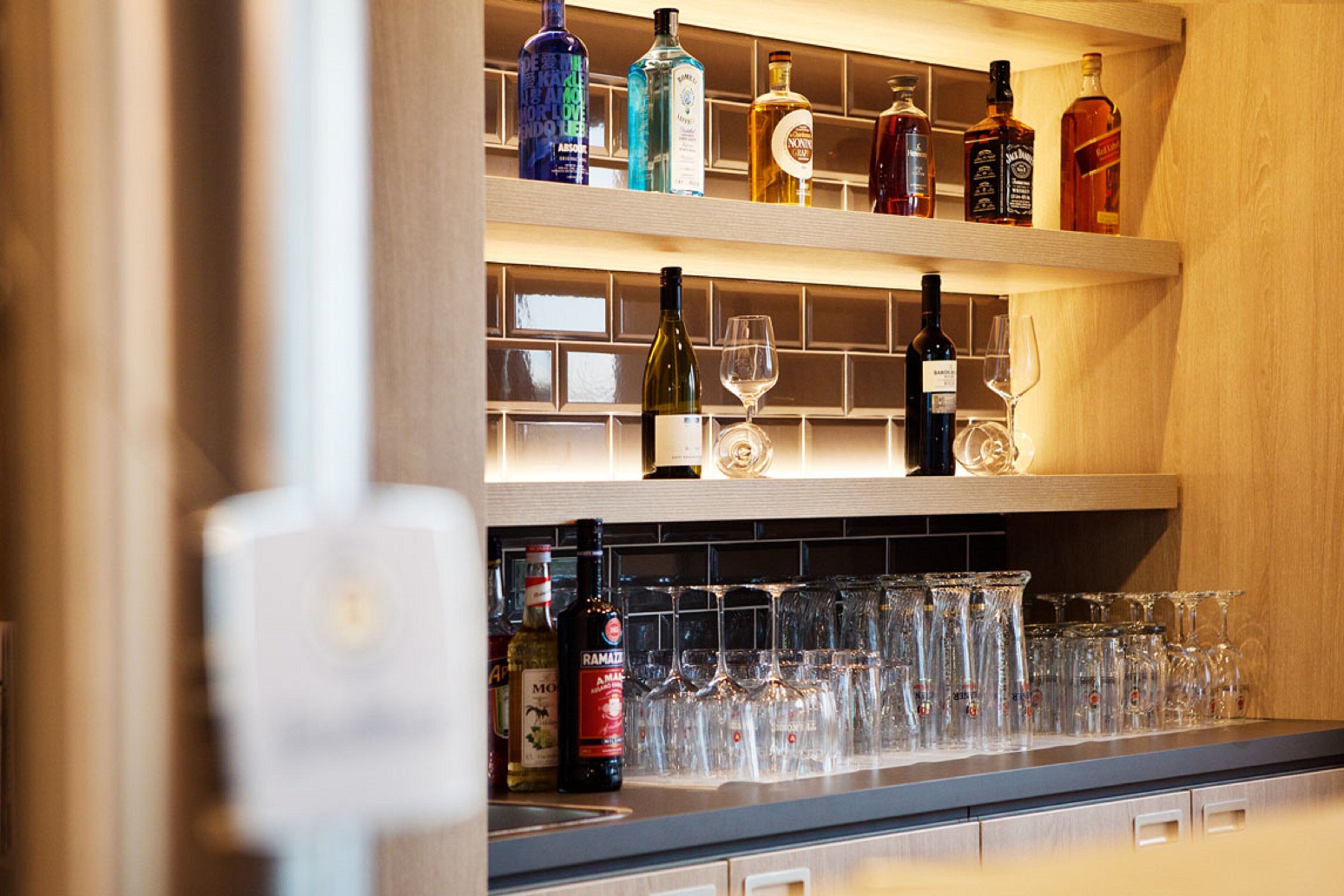 A bar area with shelves of liquor bottles and glasses.