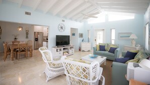 A spacious living area with a dining set, a television, and a sofa. - ALL DOCKED OUT~ Key Colony Retreat Sandy beach's and sunsets (Key Colony Beach)