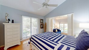 Une chambre à coucher avec un lit, une commode et un ventilateur de plafond.