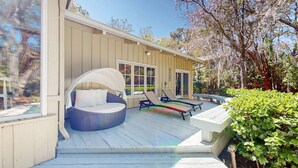 Une terrasse extérieure moderne dotée d’un espace salon circulaire, d’un espace de repos couvert et d’une table à manger.