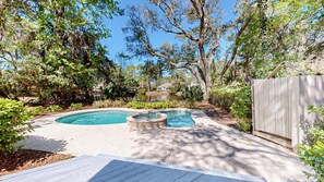 Ein Garten mit Schwimmbecken, Whirlpool und einer Holzterrasse.