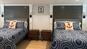 Habitación doble con dos camas, cada una con cabecero, mesita de noche y mesita auxiliar.