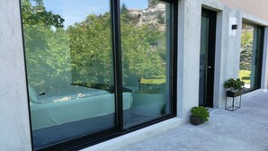 Un edificio moderno con grandes ventanales, fachada de concreto y una pequeña planta en maceta.