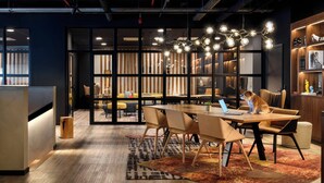 A modern meeting room with a wooden table, leather chairs, and a laptop. - Moxy Lisboa Oriente (Lisbon)