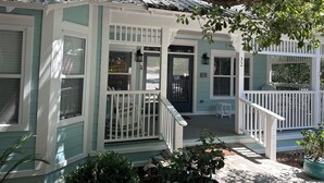 A house with a porch, a front door, and a small seating area. - Close to Seaside! Cozy Cottage. Private heated pool  (Santa Rosa Beach)