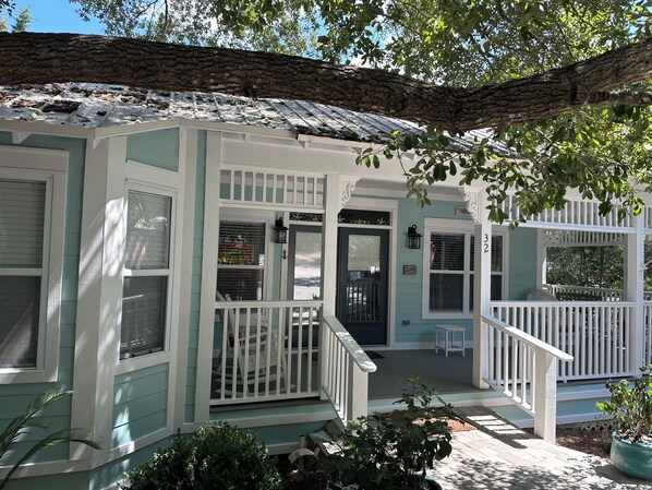 A house with a porch, a front door, and a small seating area. - Close to Seaside! Cozy Cottage. Private heated pool (Santa Rosa Beach)