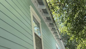 A light green house with white trim, a covered porch, and a paved driveway. - Close to Seaside! Cozy Cottage. Private heated pool  (Santa Rosa Beach)