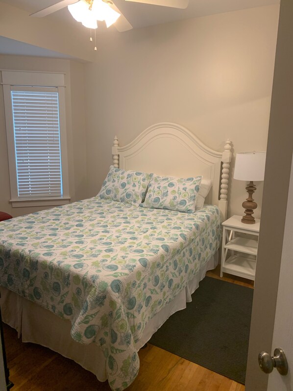A bedroom with a bed, a nightstand, a lamp, and a window with blinds. - Close to Seaside! Cozy Cottage. Private heated pool (Santa Rosa Beach)