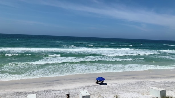 A beach with a blue umbrella and a white structure, likely a lifeguard station, on the sand. - Close to Seaside! Cozy Cottage. Private heated pool  (Santa Rosa Beach)