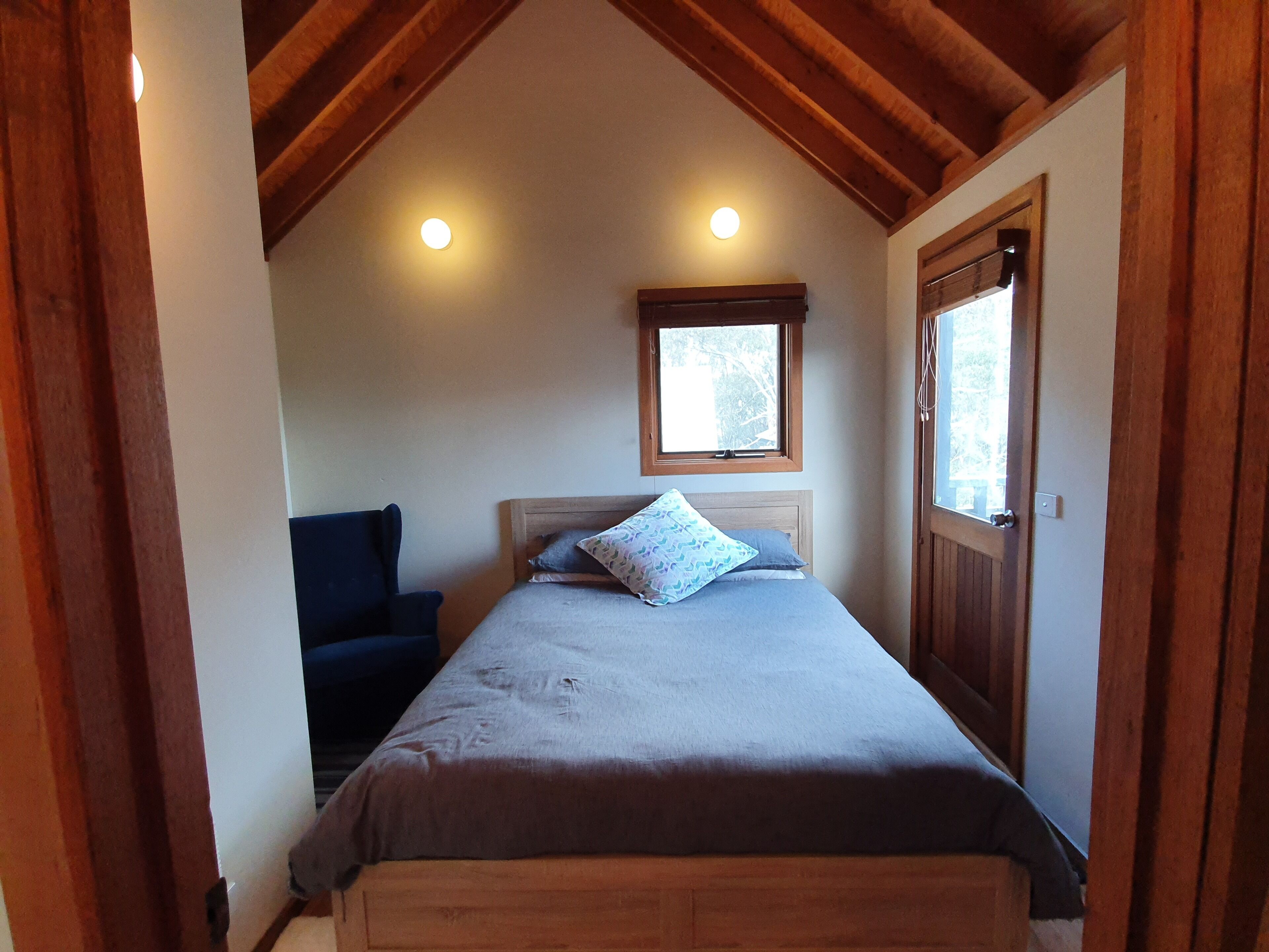 Un dormitorio con cama, ventana y puerta.
