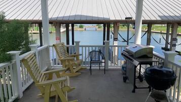 Un espace extérieur abrité, équipé d’un barbecue et de sièges.