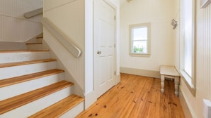 A staircase with wooden steps leading to a white door. - Laguna Harbor Cottage (Bolivar Peninsula)