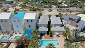 A residential area with multiple two-story houses, a central swimming pool, and surrounding greenery. - Happy Ours (Panama City Beach)