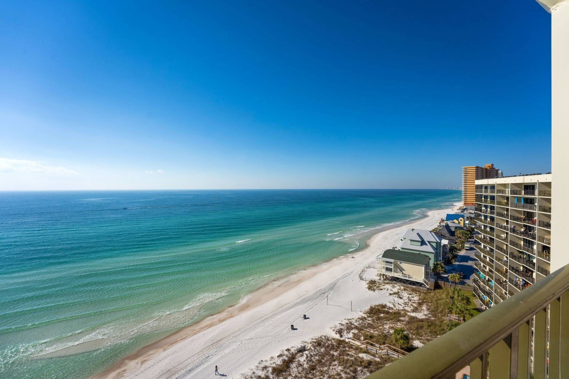 Un hôtel situé en bord de mer, offrant une vue sur l’océan et donnant accès à une plage de sable.