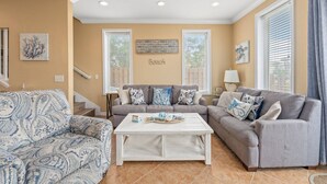 A living room with two sofas, a coffee table, and artwork on the walls.