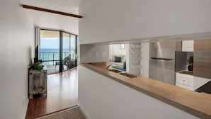 A modern kitchen with a large island, stainless steel appliances, and a view to a balcony with a glass door. - Sunbird Beach Resort 1211 E (Panama City Beach)