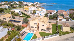 Un quartier résidentiel avec des maisons, une piscine et une vue sur la mer.