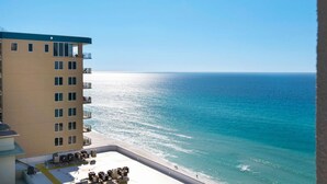 Un immeuble de grande hauteur doté de nombreux balcons donnant sur une plage.