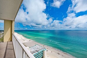 Een balkon met uitzicht op een strand en de oceaan.