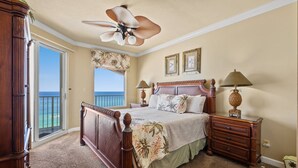 A bedroom with a large bed, a ceiling fan, a view of the ocean, and a balcony. - Marisol by iTrip Panama City Beach (Panama City Beach)