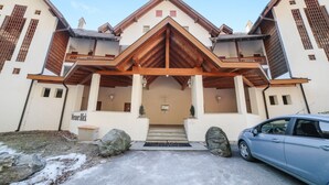 Un bâtiment doté d’une entrée imposante, une voiture garée devant, et une enseigne sur laquelle on peut lire « Meraner Blick ».