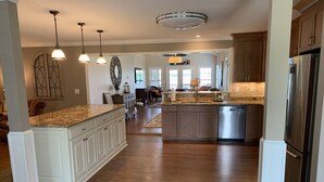 A spacious kitchen with a large island, wooden cabinets, and stainless steel appliances. - THE Premier Clemson /Seneca Lake Home  (Seneca)