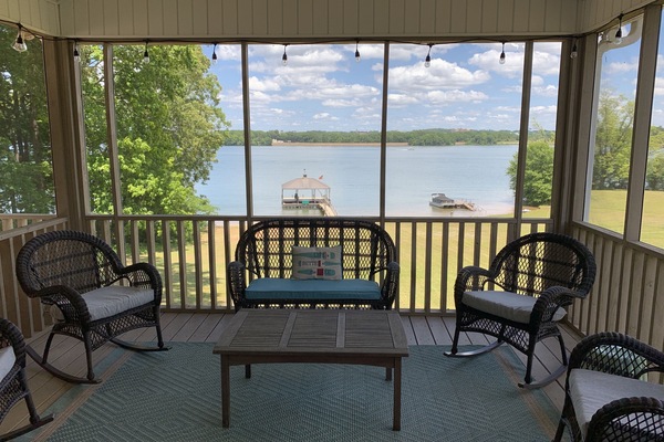 Screened in porch with lighting, ceiling fan, and large TV