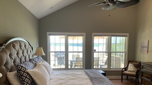 A bedroom with a large bed, two windows, a ceiling fan, and a chair. - THE Premier Clemson /Seneca Lake Home  (Seneca)