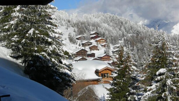 A snow-covered mountain village with wooden chalets.