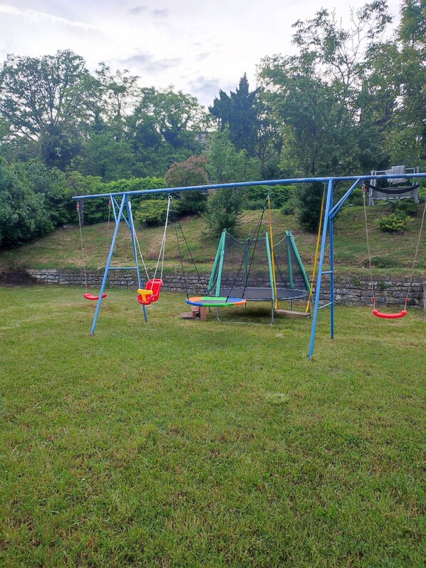 A playground with swings and a trampoline.