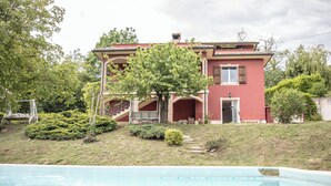 Une maison à deux étages avec une piscine en premier plan.