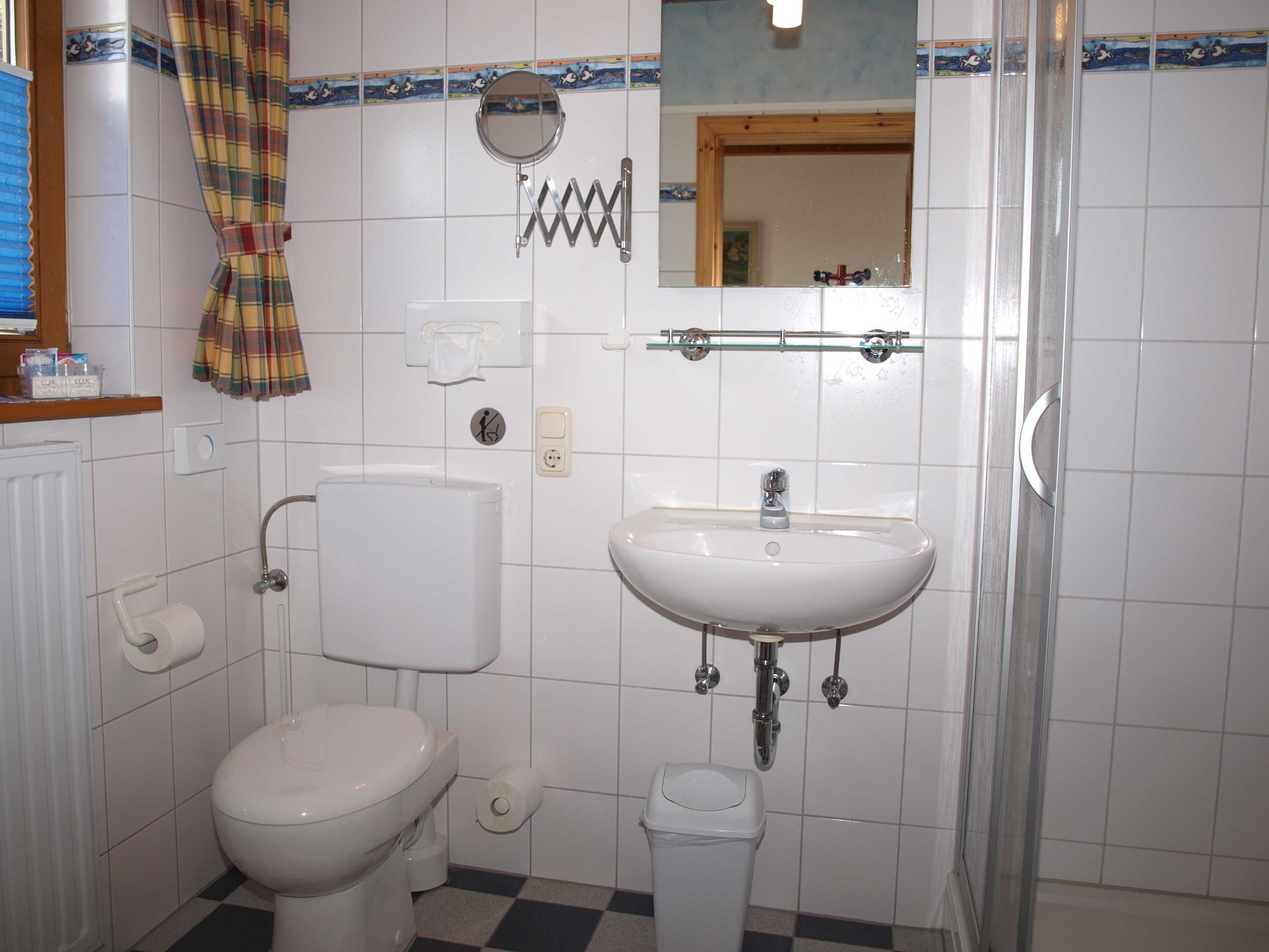 Un baño con inodoro, lavamanos y ducha.
