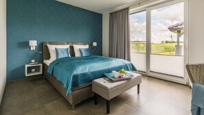 Quarto com cama, mesas de cabeceira, janela com vista e varanda.