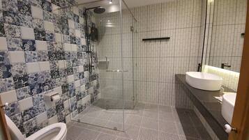A bathroom with a shower, toilet, and sink.
