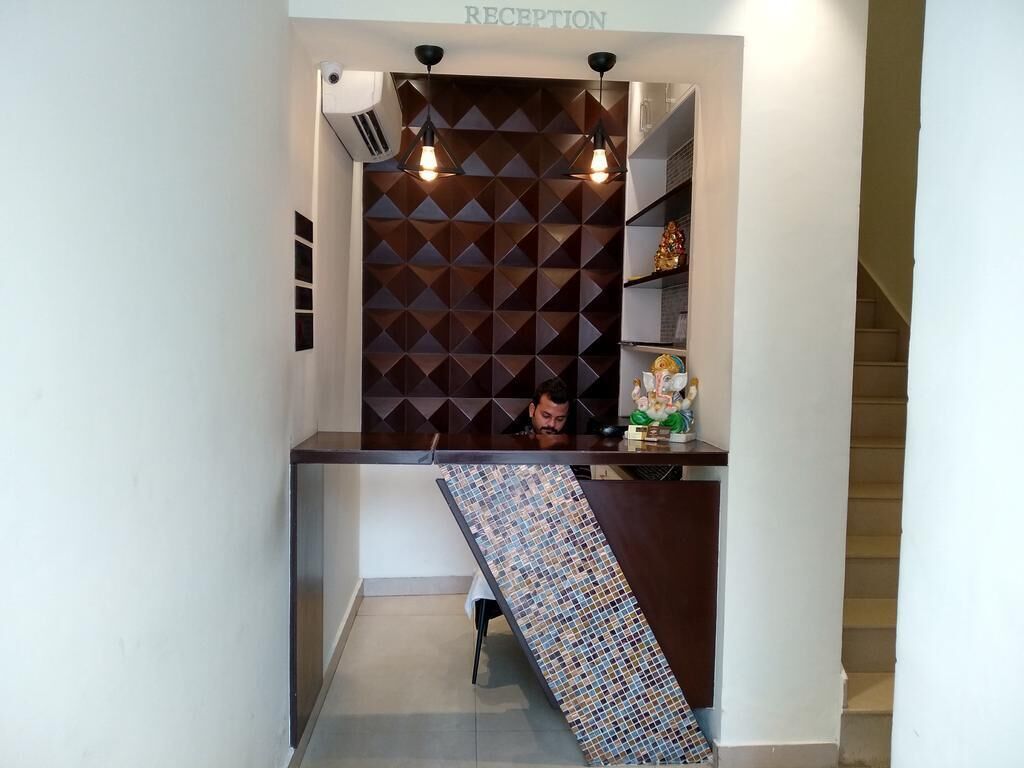 A reception area with a geometric patterned wall, a reception desk, and a staircase.
