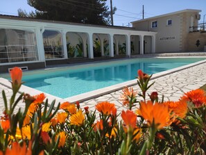 Piscine extérieure en saison, parasols, chaises longues