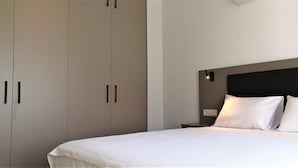 Une chambre à coucher avec un lit, une table de chevet et une armoire.