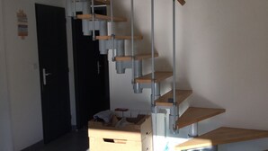 Ein modernes Interieur mit einer Treppe, Holzkisten und einer blauen Tasche auf dem Boden.