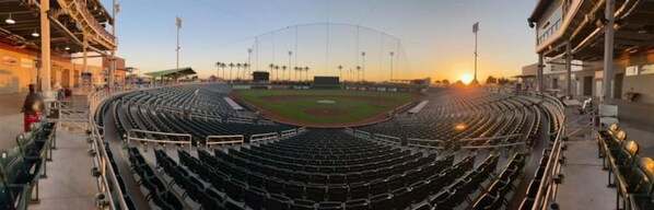 Un stade de baseball doté de plusieurs niveaux de gradins, d’un terrain central et d’un ciel dégagé.