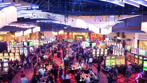 A casino with multiple gaming tables and slot machines, a high ceiling with hanging lights, and a carpeted floor. - Tru By Hilton Goodyear Phoenix West, AZ (Goodyear)