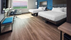A hotel room with two beds, a desk, a chair, a TV, and a large window with a view of a field. - Tru By Hilton Goodyear Phoenix West, AZ (Goodyear)