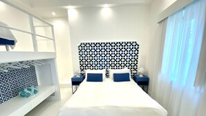 A modern bedroom with a large bed, a patterned headboard, and a white wardrobe with a blue accent. - House near the sea with Jacuzzi pool, terrace - solarium and garden (META)