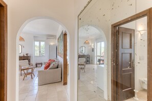 A spacious living area with a sofa, chairs, and a dining table.